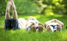 3 Freunde liegen im Gras