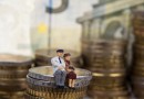 Minaturpaar sitzt auf Geld