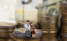 Minaturpaar sitzt auf Geld