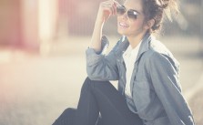 Fröhliche junge frau mit Sonnenbrille und Denim-Look