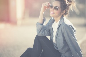 Fröhliche junge frau mit Sonnenbrille und Denim-Look